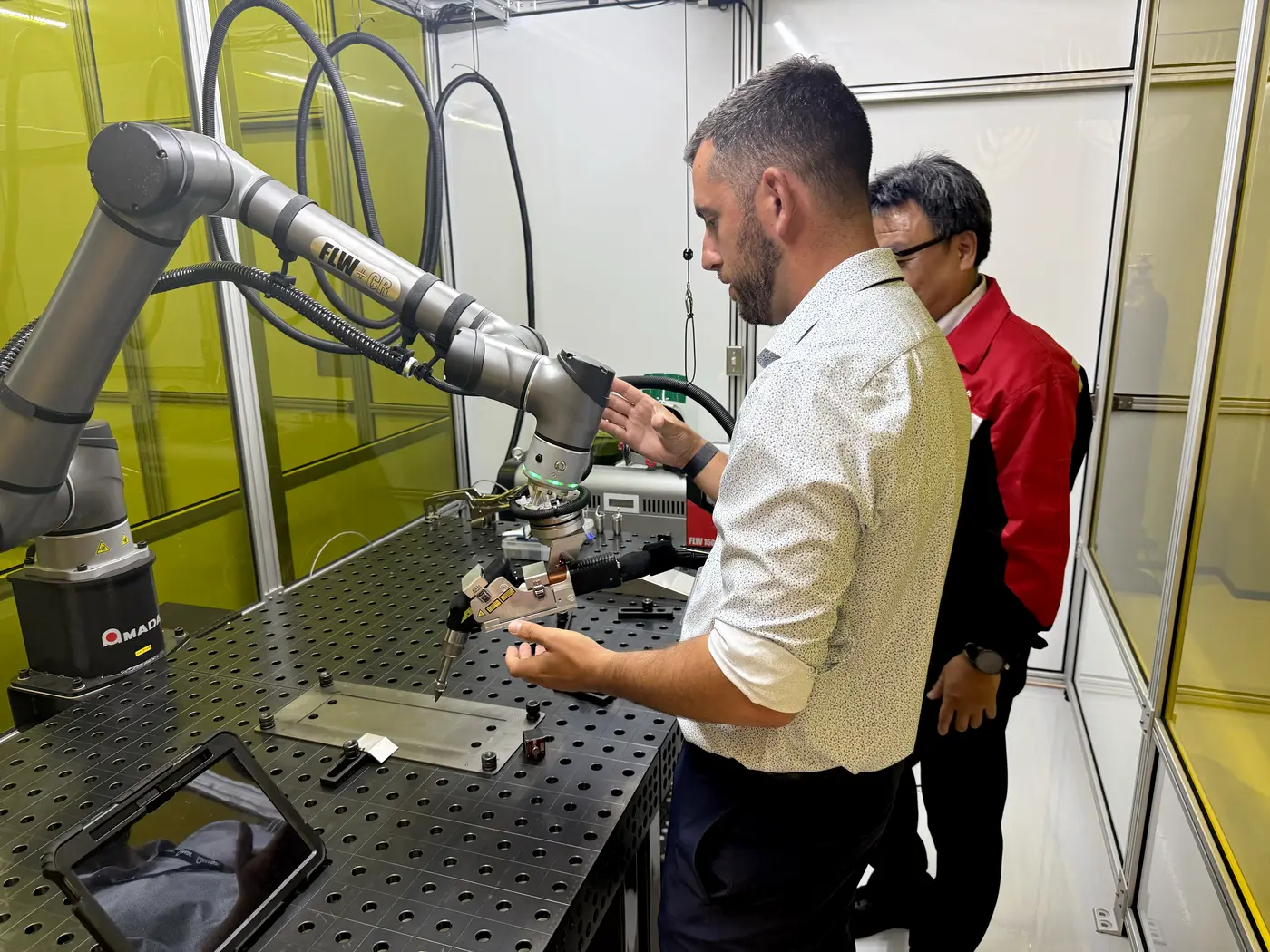 Ingeniero de aplicaciones de AMADA demostrando la celda de soldadura robótica colaborativa